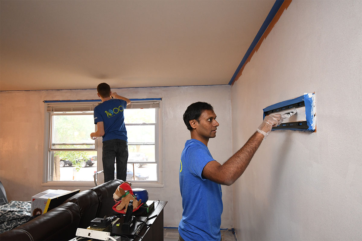 Two group volunteers painting a home